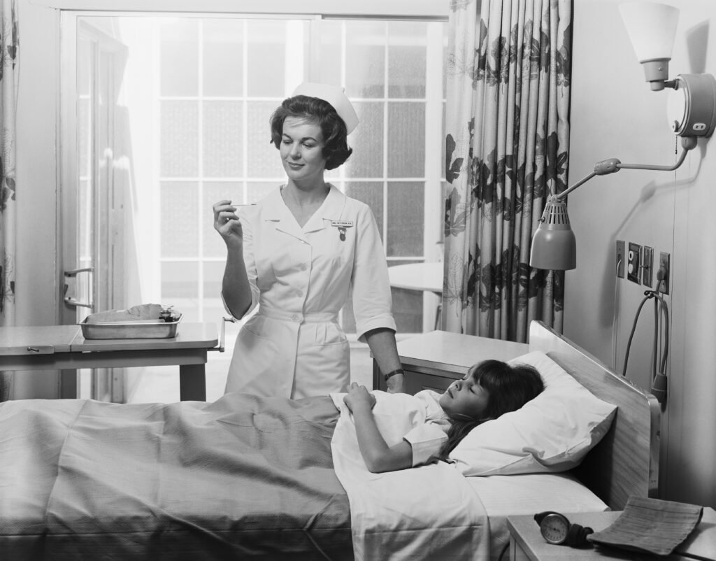 nurse on bedside of girl in hospital