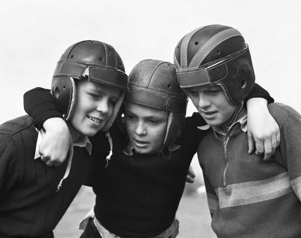 boys wearing leather football helmets